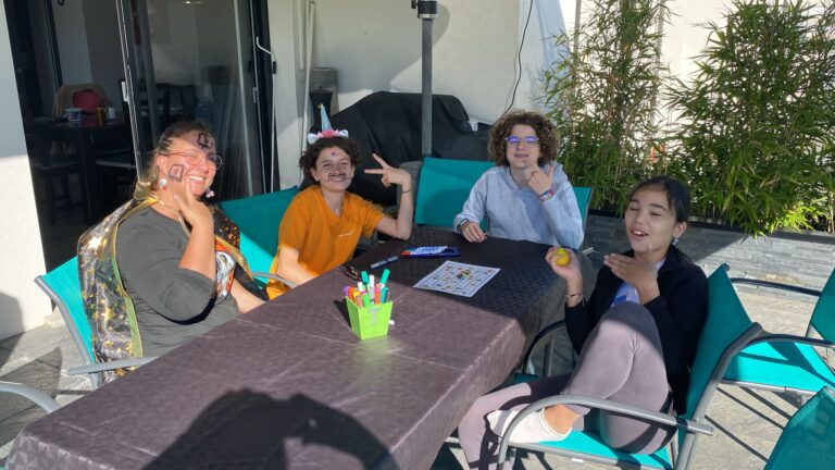 Codeuse et enfants autour d'une table en terrasse